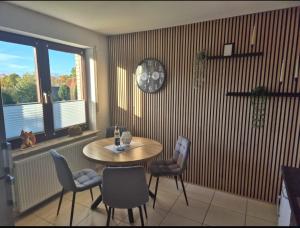 a dining room with a table and chairs and a window at Ferienwohnung Fehnzeit in Rhauderfehn +6 photos