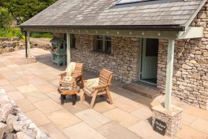 une terrasse extérieure avec deux chaises et une maison dans l'établissement Ellenboro House, Cosy Sleeps 2, Near Cartmel, à Grange-over-Sands