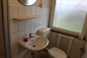 a bathroom with a sink and a toilet and a window at Bungalow 1 - 4-Raum-Wohnung mit Küche und 2 WC Duschen in Ohrdruf-Crawinkel in Ohrdruf +30 photos