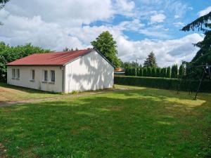 a small white building with a red roof in a yard at Bungalow 1 - 4-Raum-Wohnung mit Küche und 2 WC Duschen in Ohrdruf-Crawinkel in Ohrdruf