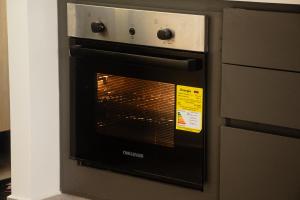 an oven with its door open in a kitchen at Frente a Viva Envigado, AC, moderno e iluminado in Envigado +12 photos