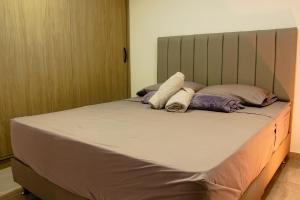 a bed with two pillows on it in a room at Frente a Viva Envigado, AC, moderno e iluminado in Envigado