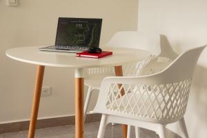 a white table with a laptop on top of it at Frente a Viva Envigado, AC, moderno e iluminado in Envigado