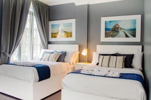 two beds in a bedroom with a window at Hotel Bijoux in Plaridel