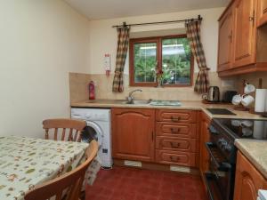 a kitchen with a table and a sink and a dishwasher at Denhill Cottage in Taunton +15 photos