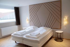 a bedroom with a white bed with a wooden headboard at A Hotels Roskilde in Hedehusene +56 photos