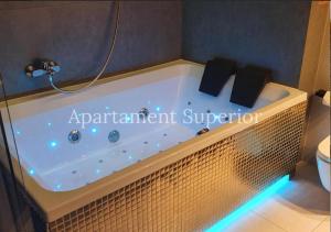 a bath tub in a bathroom with a sign that reads apartment supplement supplement at Jacuzzi Glass-House Central Station in Kraków