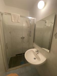 a bathroom with a sink and a shower with a mirror at Ganzha Appart in Medulin +20 photos