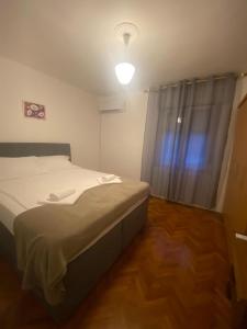 a small bedroom with a bed and a light at Ganzha Appart in Medulin