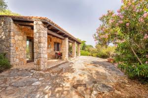 einen externen Blick auf ein Steinhaus mit einem Weg in der Unterkunft Village surrounded by greenery with swimming pool just a few minutes from Alghero in Alghero + 18 Fotos