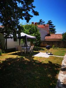 a backyard with a table and chairs under a canopy at Ganzha Appart in Medulin