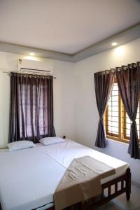 a bedroom with a large bed and a window at Marari Irine Homestay in Mararikulam