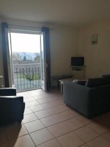 Una sala de estar con un sofá y una puerta corrediza de vidrio. en Gordes Le Bastidon, en Gordes 26 fotos más