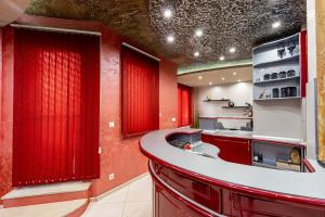 Eine Küche mit roten Vorhängen und einer roten Arbeitsplatte in der Unterkunft Beni Deluxe 1 in Plowdiw