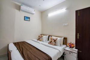 a bedroom with a bed with white sheets and pillows at AAFIYA LAKEVIEW APARTMENTS in Coimbatore