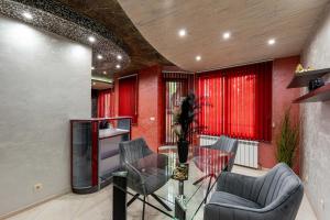 ein Wohnzimmer mit einem Glastisch und Stühlen in der Unterkunft Beni Deluxe 1 in Plowdiw