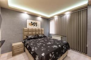 ein Schlafzimmer mit einem Bett und einem großen Fenster in der Unterkunft Beni Deluxe 1 in Plowdiw