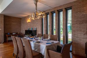 ein Esszimmer mit einem Tisch mit Stühlen und einem Kronleuchter in der Unterkunft VILLA AMYRA 6&2, Emma Villas in Madonna della Pace