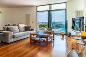 ein Wohnzimmer mit Sofa und Tisch in der Unterkunft VILLA AMYRA 6&2, Emma Villas in Madonna della Pace