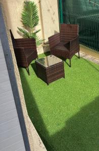 three chairs and a table on some grass at Apparemment rénové- 2 appartements au choix in Bourg-de-Péage