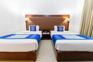 two beds in a hotel room with blue and white sheets at Ajantha Regency in Cochin