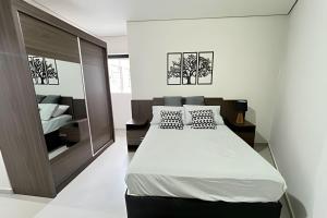 ein Schlafzimmer mit einem großen Bett und einem Spiegel in der Unterkunft Residencial Piranji in São Paulo