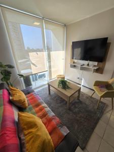 a living room with a couch and a flat screen tv at Nuevo cómodo dep a pasos del mall open Rancagua in Rancagua