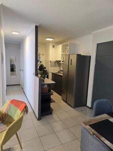 a kitchen with a refrigerator and a table and chairs at Nuevo cómodo dep a pasos del mall open Rancagua in Rancagua