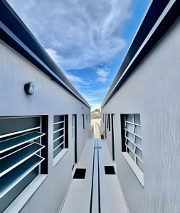 Ein Flur zwischen zwei Gebäuden mit dem Himmel im Hintergrund in der Unterkunft Residencial Piranji in São Paulo