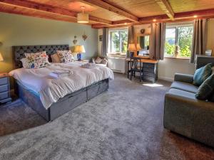 une chambre avec un grand lit et un canapé dans l'établissement Hadrians Garden Villa, à Bardon Mill