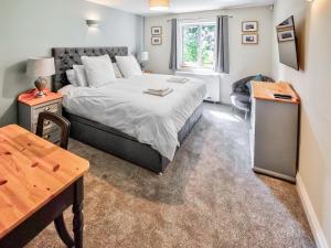 une chambre avec un grand lit et une table dans l'établissement Hadrians Garden Villa, à Bardon Mill 22 autres photos