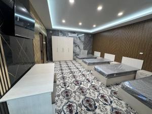 a room with two beds and a room with a floor at Amiriy hostel in Bukhara