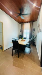 a dining room with a table and chairs at Rooma Kichi Private Pool in Pantai Cenang +36 photos