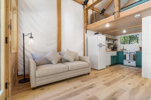 a living room with a couch and a kitchen at Cedar Creek - Glamping in the Ozarks in Walnut Shade