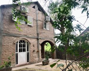 an old brick house with a white door at Complejo Turístico Hugo Ávila in La Rioja