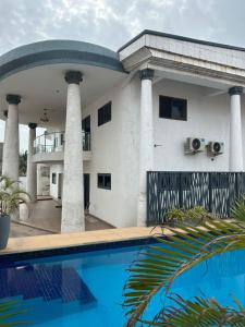 a house with a swimming pool in front of it at Jessica's Villa in Accra