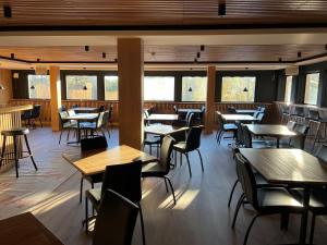 a restaurant with tables and chairs and windows at Hotel Munkfors in Munkfors