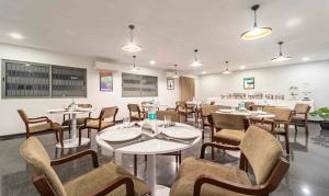 a restaurant with tables and chairs in a room at Treebo Skyry Residency in Coimbatore