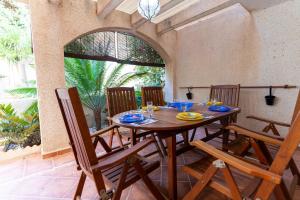 a wooden table and chairs in a room with a window at rentafive - Piscina - Playa - Adosado in Gran Alacant