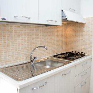 una cucina con lavello e fornello di Le Casette di Vita a Sciacca