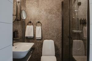a bathroom with a toilet and a sink and a shower at Home Hotel Cardinal in Växjö +70 photos