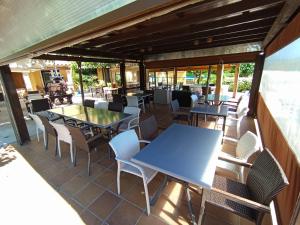 an outdoor patio with tables and chairs and windows at Hotel Les Roques in Báscara
