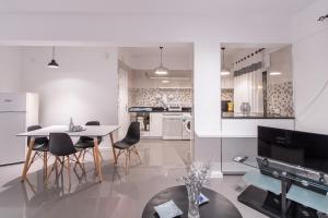 ミンデロにあるMindelo Downtown Stayの白いキッチン(ダイニングテーブル、椅子付)