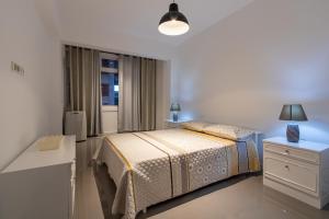 ミンデロにあるMindelo Downtown Stayのベッドと窓のある白い寝室