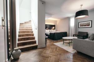 レイキャビクにあるアポテック ホテル レイキャビク バイ ケアホテルズのベッドルームへ続く階段付きのリビングルーム +56枚の写真