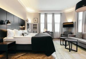 レイキャビクにあるアポテック ホテル レイキャビク バイ ケアホテルズのベッドとソファのあるホテルの部屋