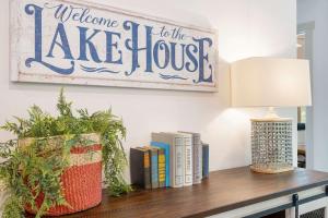 a welcome to the lake house sign on a table with books at New Lakeside Haven - Picturesque in Branson