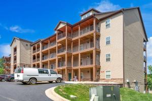 a large apartment building with a van parked in a parking lot at New Lakeside Haven - Picturesque in Branson