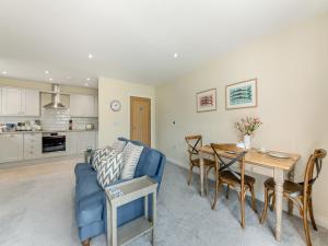 ein Wohnzimmer mit einem blauen Sofa und einem Tisch in der Unterkunft Nightfold - Uk49890 in Preston