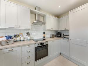 eine weiße Küche mit weißen Schränken und Geräten in der Unterkunft Nightfold - Uk49890 in Preston